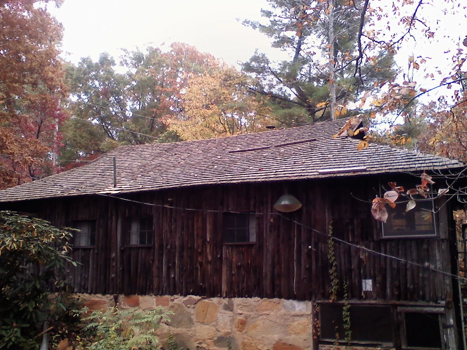 Weathered wood shake roof on a rustic board sided cabin in Montville