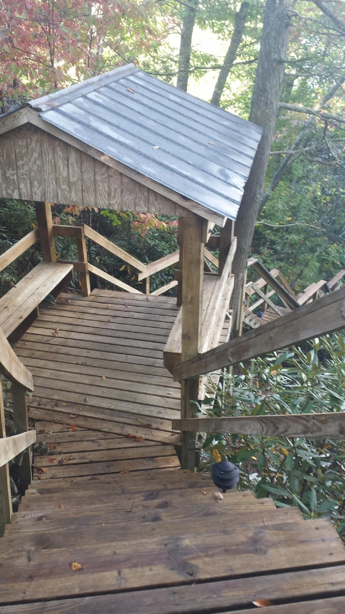Metal roofed shelter over wooden steps on a wooded walkway — Skylight Repair & Installation work by our crew in Montville