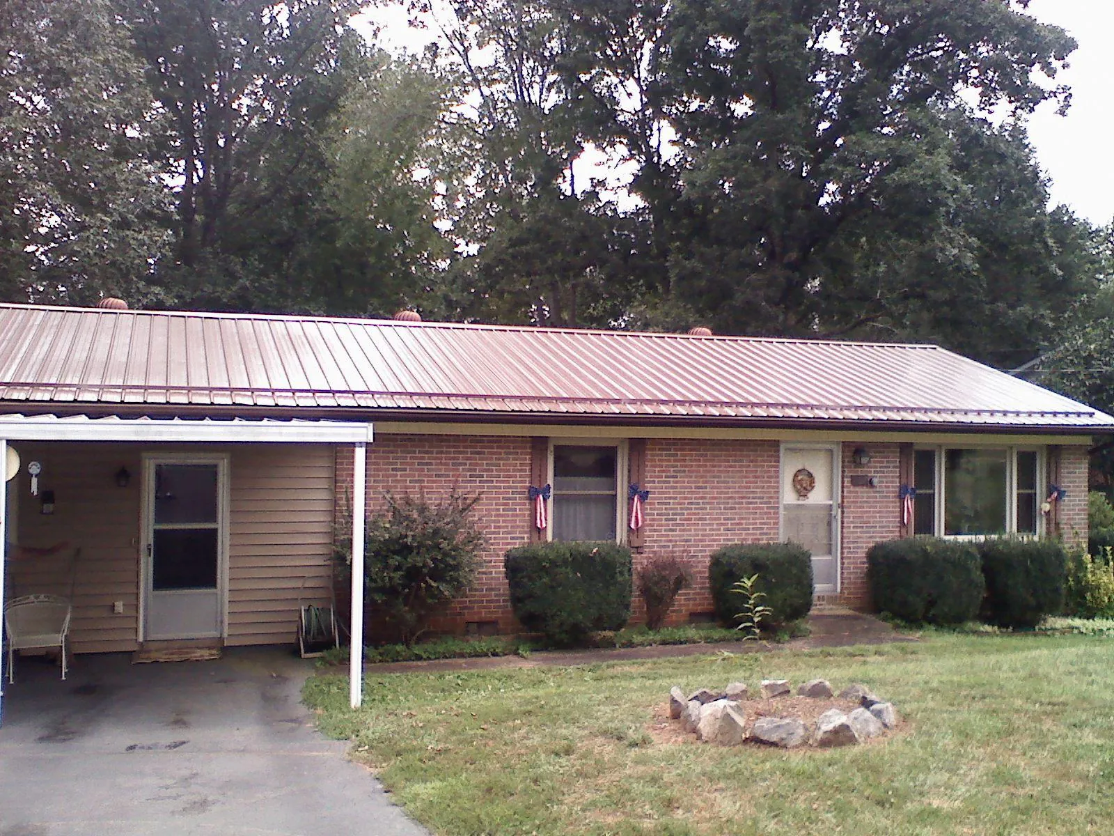 Bronze metal roof and carport on a brick ranch home — Roof Repair work by our crew in Montville