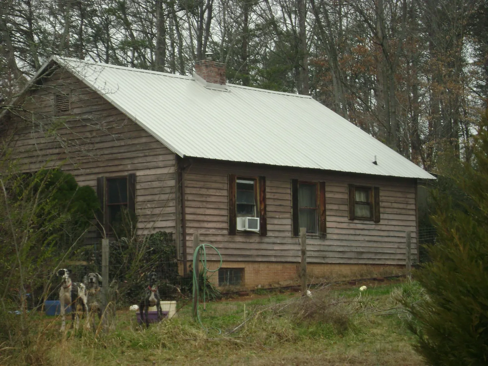 White metal roof on an old wood sided farmhouse, from a Metal Roof Installation job in Montville